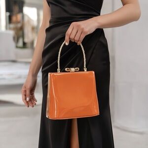 patent leather minaudière clutch with frame clasp orange